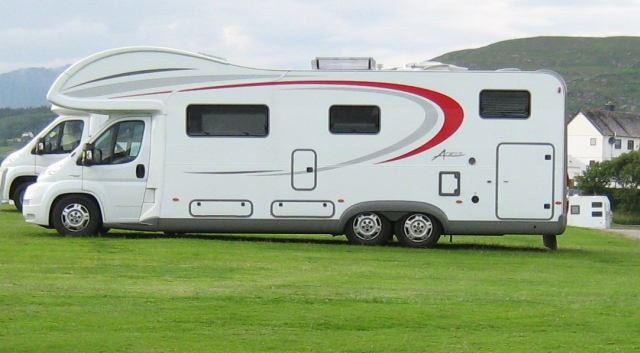 a large long white motorhome at brromfeild campsite ullapool